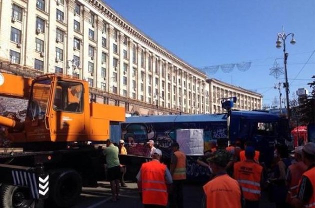 На Майдане коммунальщики начали разбирать баррикады, активисты подожгли покрышки