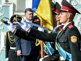 Президент держит флаг, переданный ему накануне 81-й бригадой из зоны АТО. Флаг побывал в Донецком аэропорту