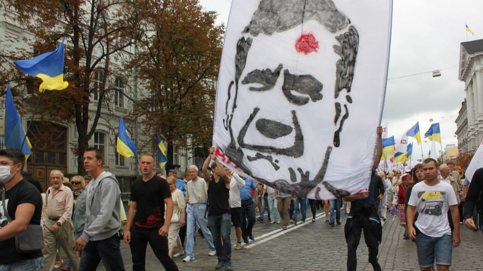 Во время шествия оппозиции милиция отбила у активистов баннер с изображением Януковича с красной точкой на лбу