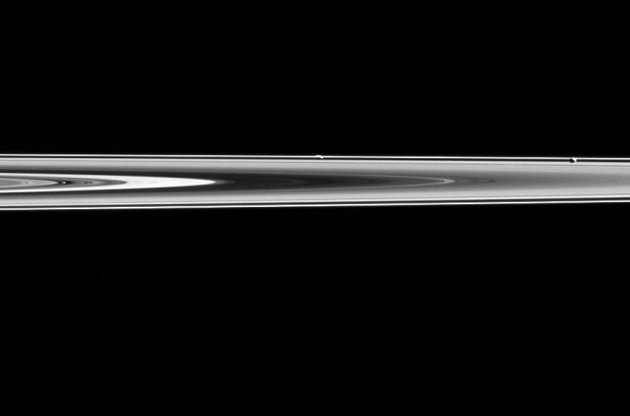 Станция Cassini запечатлела два спутника Сатурна на фоне колец