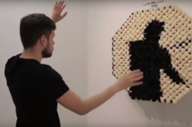 Зеркало из бежевых и черных помпонов способно отобразить силуэт человека