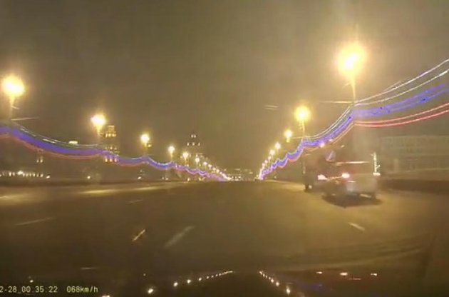 Біля тротуару видно дві машини