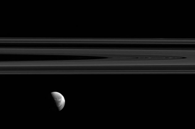 Cassini передала на Землю снимок "зависшей" под кольцами Сатурна Дионы