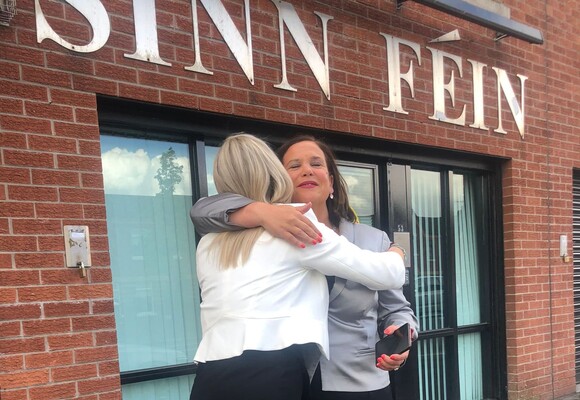 Лідери партії "Шин Фейн" - Мері Лу Макдональд і Мішель О'Ніл - обіймаються після новини про близьку перемогу їхньої партії.