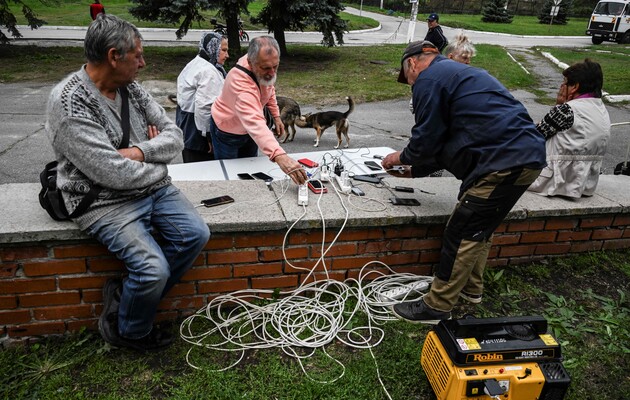 Жителі заряджають свої мобільні телефони на одній із вулиць у Балаклії, Харківська область, 17 вересня 2022 р.