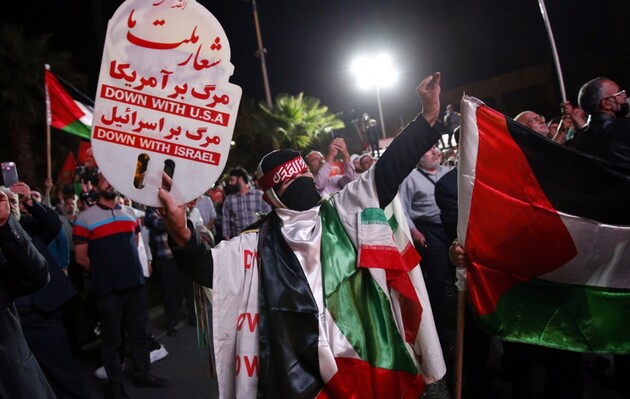 Иранские поклонники Хезболлы размахивают палестинскими флагами во время празднования атак боевиков ХАМАС на Израиль