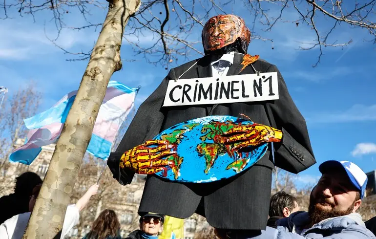 Чоловік тримає опудало Владіміра Путіна під час мітингу в Парижі / 23 лютого 2025 року