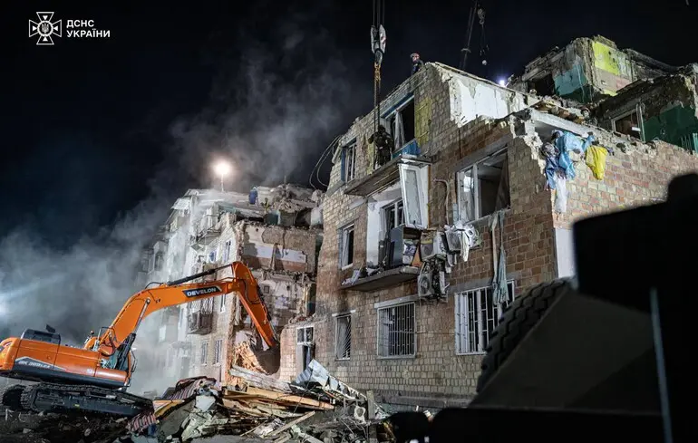 Разбор завалов на месте удара по жилому дому в Дарницком районе