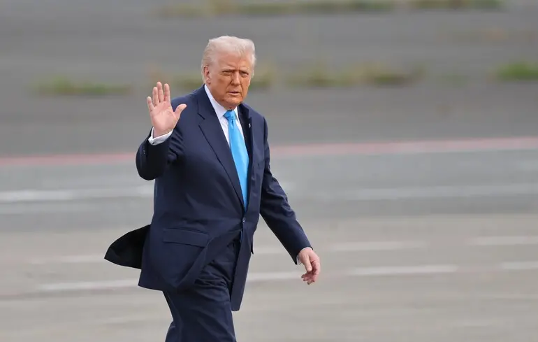 Президент США Дональд Трамп машет рукой, направляясь в самолет Air Force One, который отправлялся в Южную Корею, в аэропорту Ханэда в Токио, Япония/29 октября 2025 года