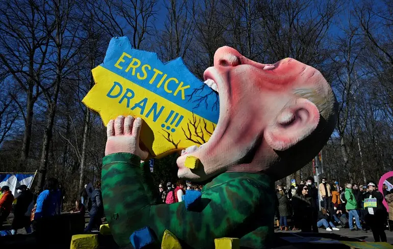 Фигура Путина, который глотает карту Украины, во время демонстрации против вторжения России в Украину в Берлине