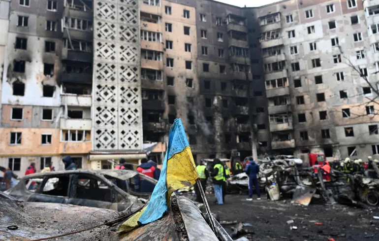 Ukrainian flag on a burned-out car near a badly damaged house after a Russian airstrike on the city of Ternopil / November 19, 2025