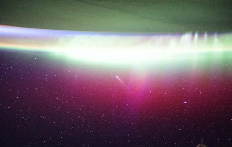 Полярное сияние излучается над Землей и поглощает комету Lemmon.