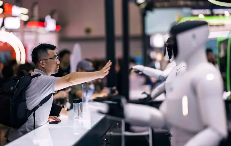 Посетитель взаимодействует с роботами, представленными на выставке WAIC в Шанхае, Китай / 28 июля 2025 года