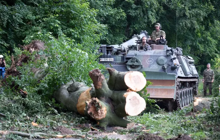 Немецкая военная инженерная машина Dachs расчищает деревья после грозы в Дюссельдорфе, Германия / 13 июня 2014 года