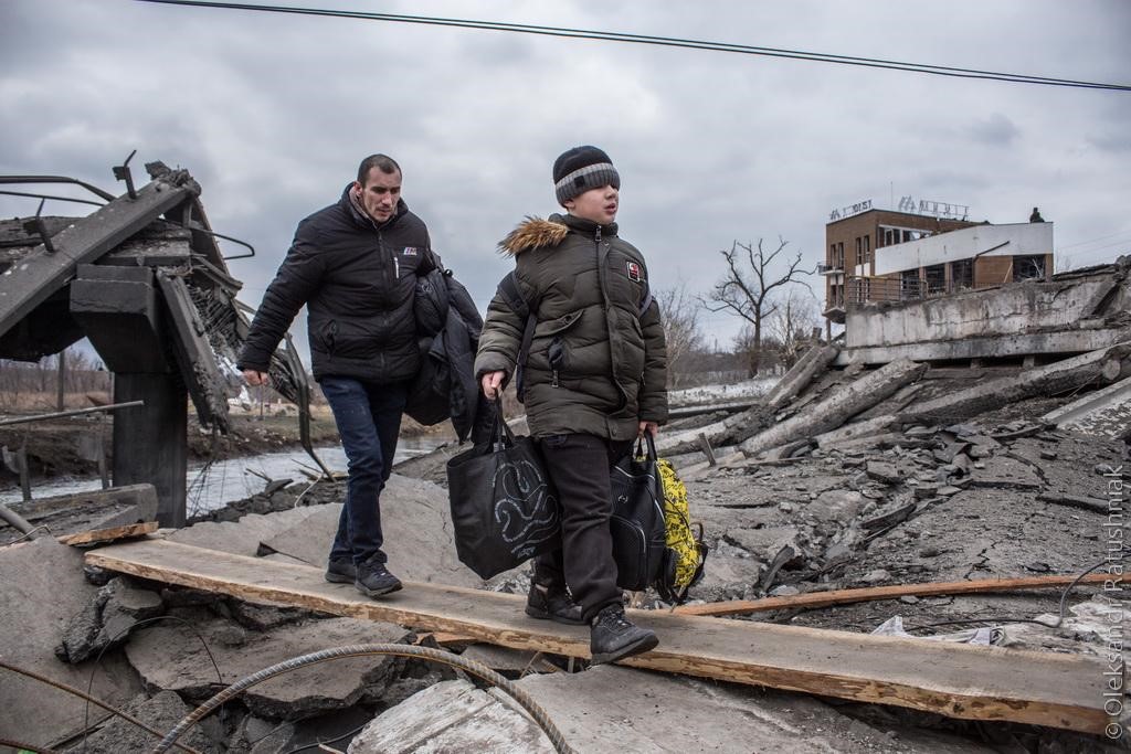 Сын Натальи несет вещи через мост на Романовке. Фото - Александр Ратушняк.