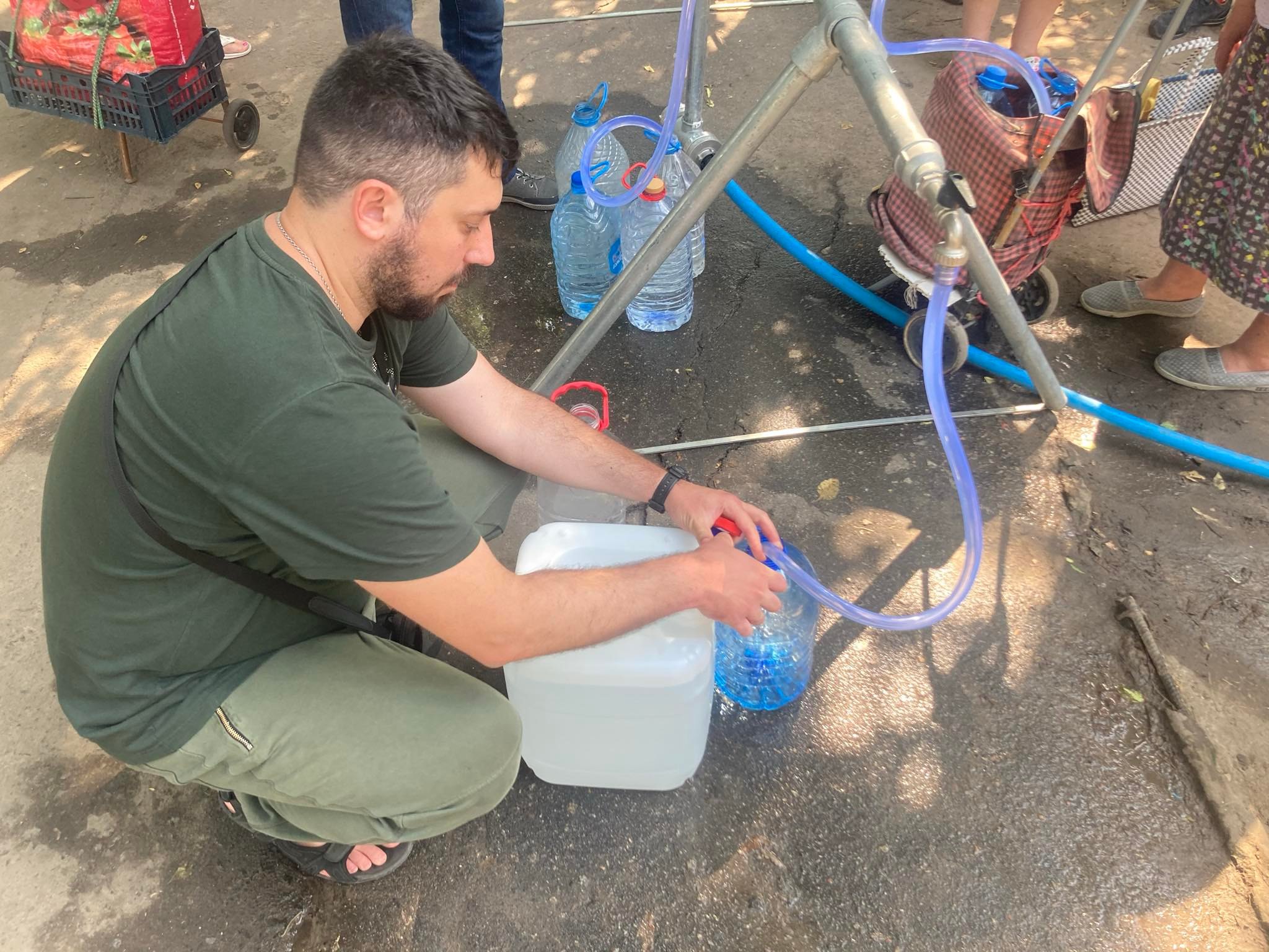 Місцеві жителі в Миколаєві набирають питну воду, липень 2022 року