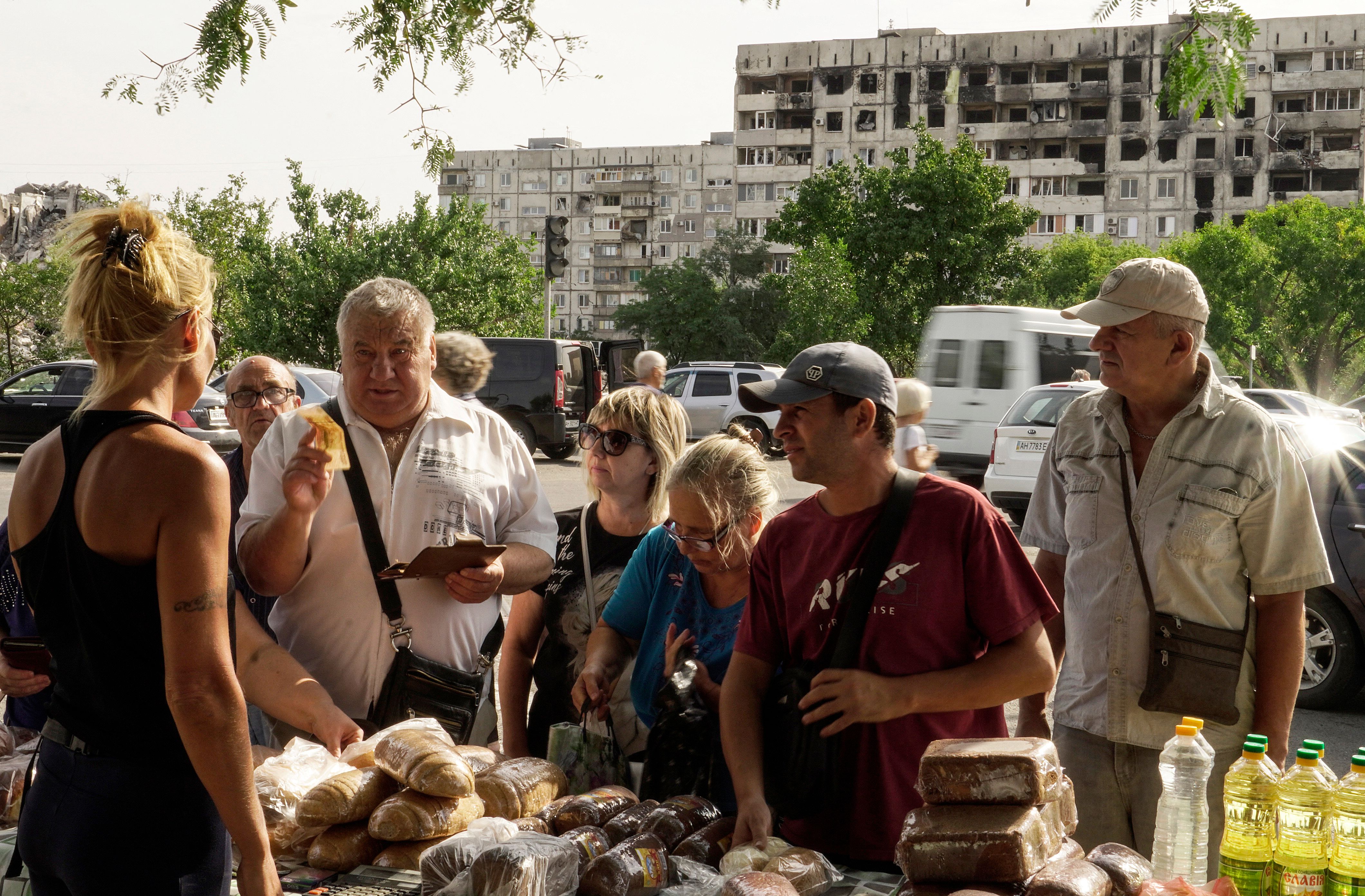 Жителі Маріуполя купують продукти на імпровізованому ринку, 27 серпня 2022 року Жителі Маріуполя купують продукти на імпровізованому ринку, 27 серпня 2022 року