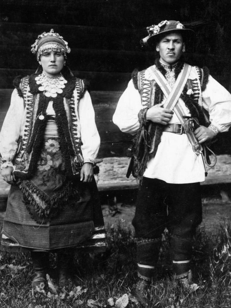 Николай Сеньковский. Молодая пара в свадебном наряде: невеста во главе с цветочным начебником, с тяжелой сгардой с монетами и крестом, в кептаре с цветочной вышивкой; жених в цветастой кресане, с перекрестными кожаными ремнями через грудь. Гуцульщина, конец 1920-х – начало 1930-х гг.