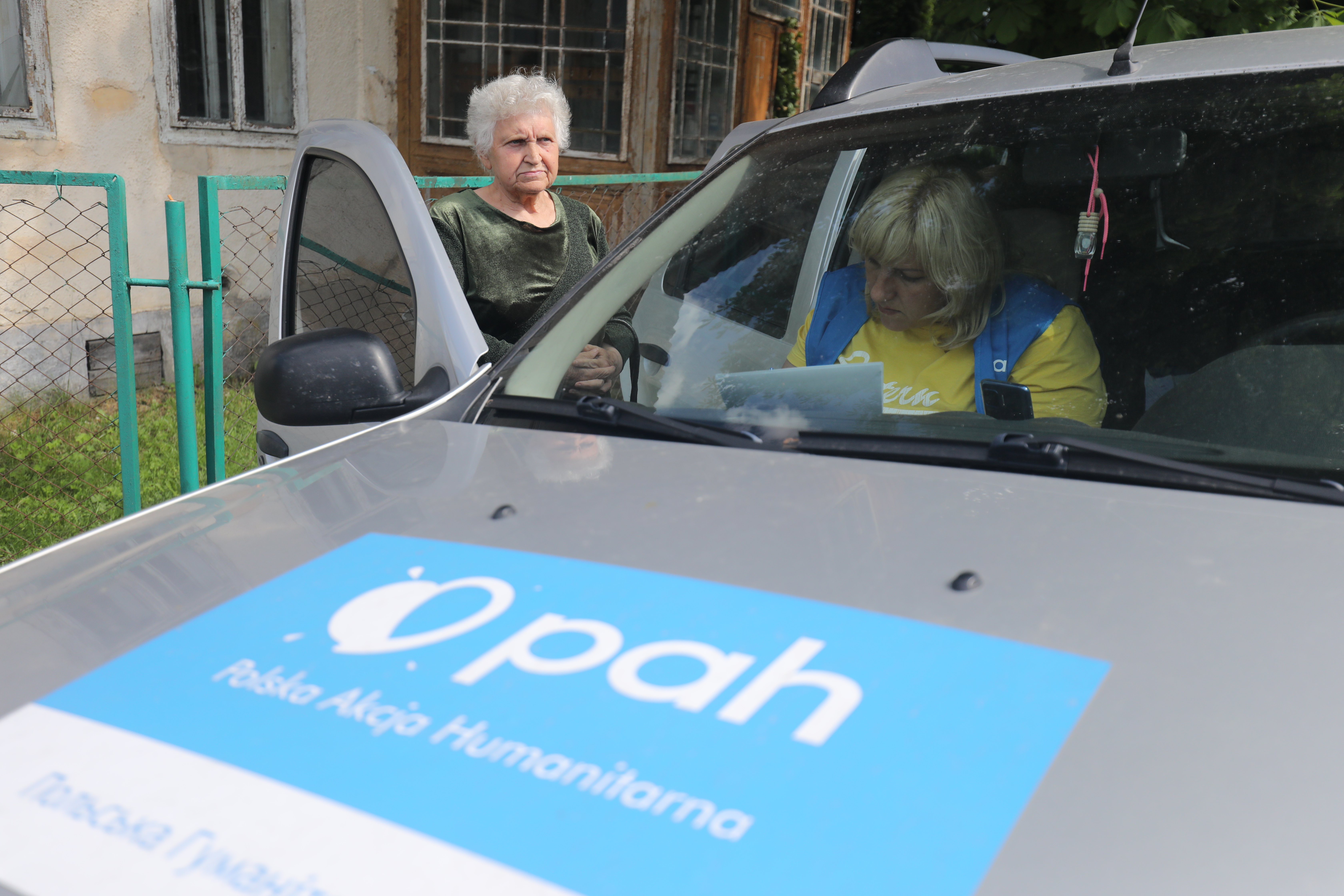Фахівчиня PAH спілкується з жителькою прифронтової громади під час польового візиту