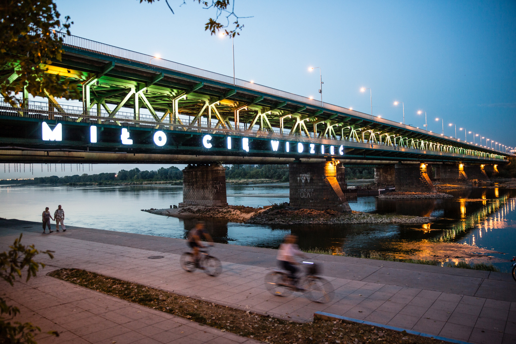 Річка Вісла та міст у Варшаві, на мосту надпис «Раді бачити вас» 