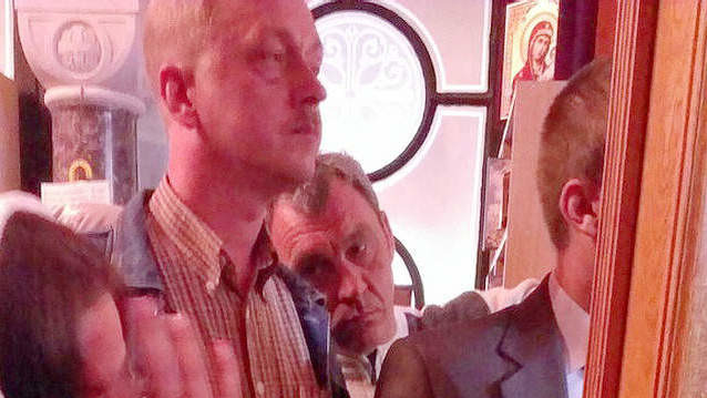 Охранник президента не пропускает верующих в зал, где идет богослужение