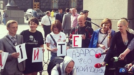 Журналисты держат в руках плакаты "Азаров, чьо такой дерзкий?"