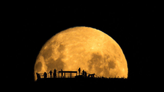 Фотография "Силуэты Луны", также выполненная главным победетелем конкурса Марком Джи, была признана лучшей в категории "Люди и космос". Это только кажется простой фотографией людей на фоне восходящей Луны. Снимая людей на смотровой площадке издалека, фотограф акцентировал внимание на их крайне маленьком размере по сравнению с огромной величиной нашего естественного спутника.