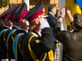 Президент держит флаг, переданный ему накануне 81-й бригадой из зоны АТО. Флаг побывал в Донецком аэропорту