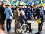 Президент тримає прапор, переданий йому напередодні 81-й бригадою із зони АТО. Прапор побував у Донецькому аеропорту