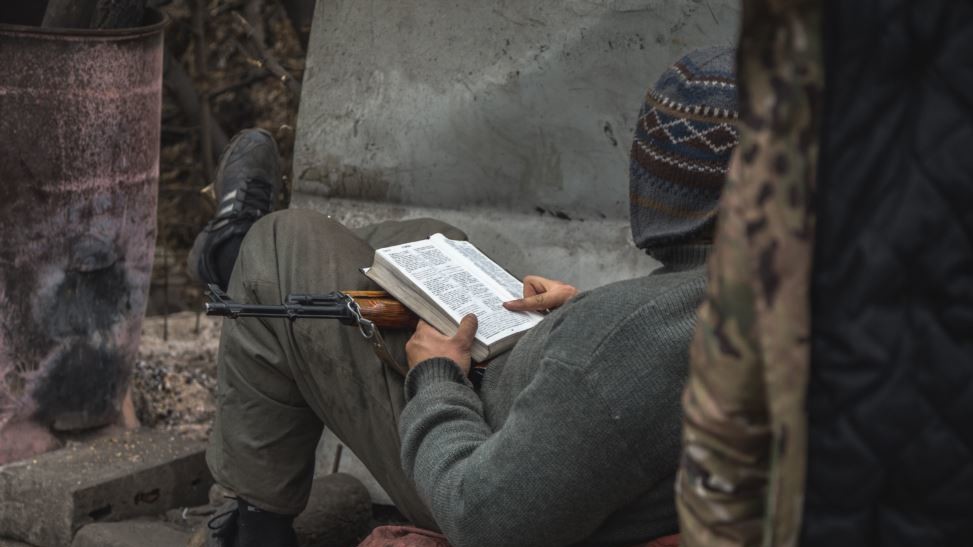 Украинский боец читает на блокпосту