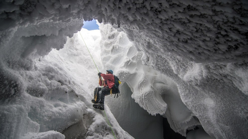 Учёный поднимается из ледяной пещеры возле вершины вулкана Эребус в Антарктиде. (© Alasdair Turner)