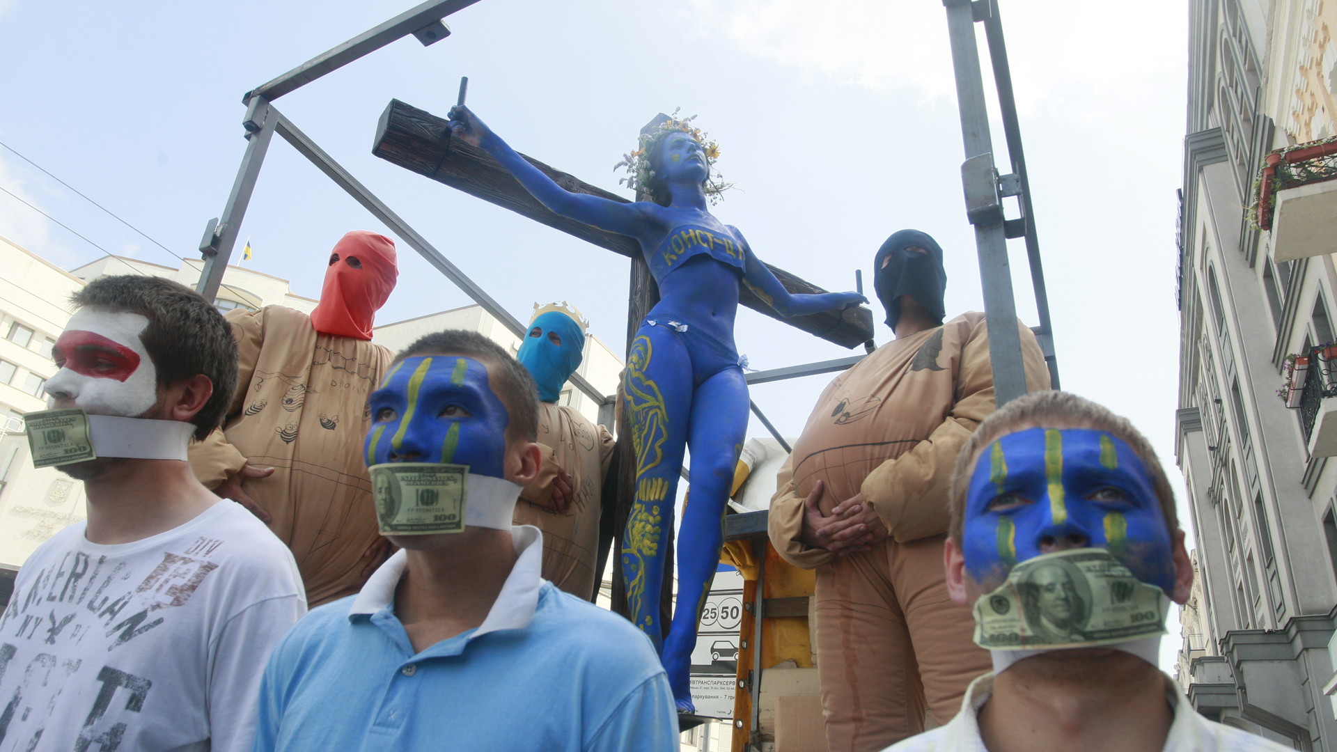 Представители оппозиционных политических сил за акцией наблюдали молча, ведь им мешали стодолларовые купюры, которыми им заклеили рот.