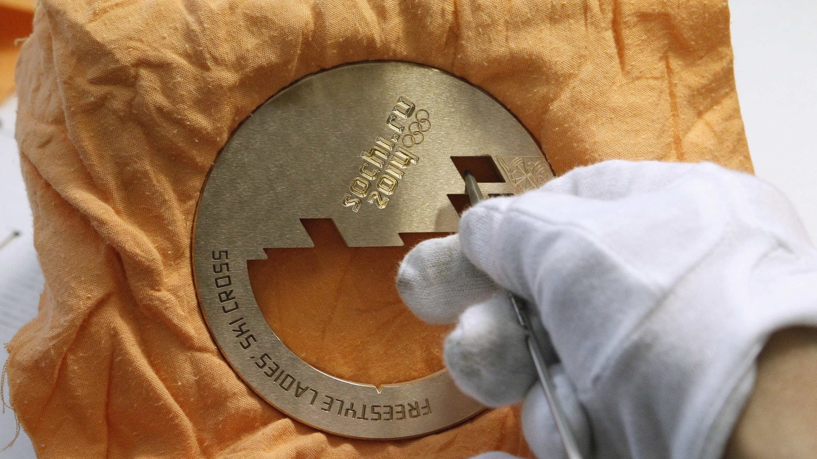 Потом заготовка отправляется на фрезеровку, где наносятся узоры, символы Олимпиады, названия дисциплин. Методом высокоскоростного фрезерования подготавливается карман под крепление ленты.